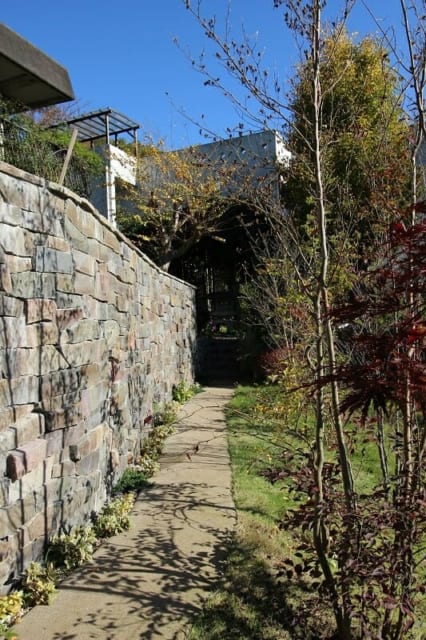 小さなコンクリート塀には鉄平石を張って、外からも雰囲気よく見えるように。園路もつけて歩けるようにした。
