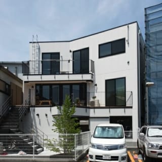 前面道路から見る住居部分とは対照的な、南側に開いた開放的な住居。プライベートな外階段を上がると広いテラスが広がり、そこを通って玄関に入る。