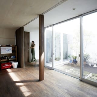 1階の子ども部屋から中庭を望む。写真中央部の柱は、将来、部屋を２つに分割するためのもの。子ども部屋の扉は常に開け放っているそうだ