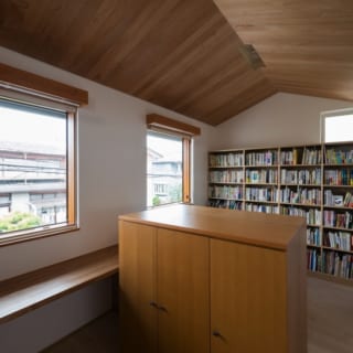 2階書斎／前の住まいから持ってこられた書棚を仕切にして、窓や本棚などを左右対称に配した書斎。切妻屋根の形を活かして空間に広がりを持たせた天井には、色味の美しいアルダー材を用いた