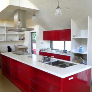 オープンキッチンは、白を基調にモダンでポップな赤でアクセントをつけ、隣接するリビング、ダイニングと異なる雰囲気に。家事動線に合わせてシンプルな棚を造作、使い勝手のよさはWさん夫人のお気に入りだ。