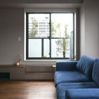 リビング／バルコニーへ出る窓は下枠が高いため、造り付けのテレビボードは階段も兼ねている。空間の印象を大きく左右するソファや電動ブラインドは、伊藤さんも一緒に見に行って選んだ
