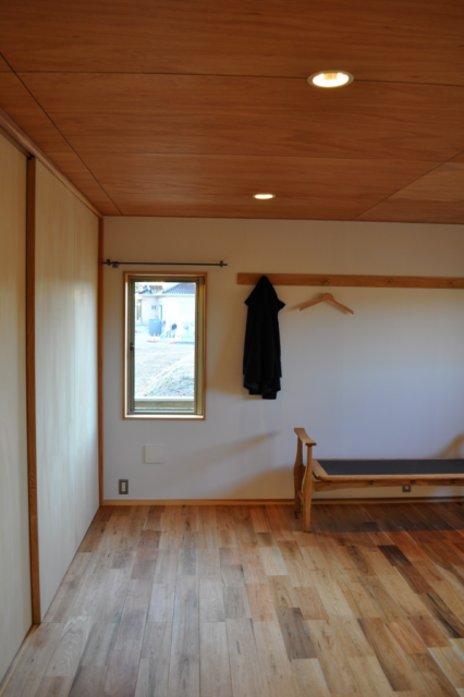 主寝室／天井と床の木の風合いを引き立てる砂漆喰の壁