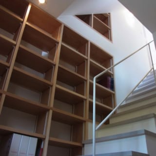 1階　書棚／書棚は1階から2階への階段にもあり、収納力たっぷり。「階段は家の中で唯一の“上下に移動するところ”。その特性を活かして使い方や過ごし方を楽しんでいただけると思います」と山本さん