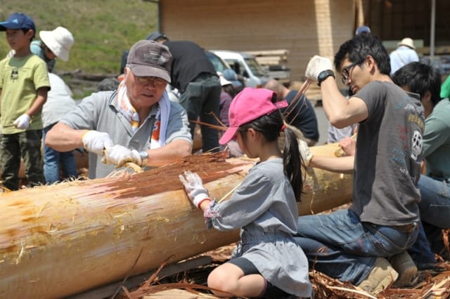 丸太の皮をむくイベントに、施主様も家族で参加。桧や杉の皮は簡単に竹ベラでむけるので、子どもでも楽しめる
