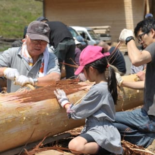 丸太の皮をむくイベントに、施主様も家族で参加。桧や杉の皮は簡単に竹ベラでむけるので、子どもでも楽しめる