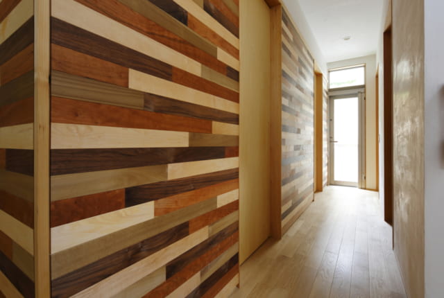 1階　廊下／様々な色の木を使ったモザイク模様が、寄木細工を思わせる落ち着きを与える。居室のドアを引き戸にすることで、和の雰囲気も