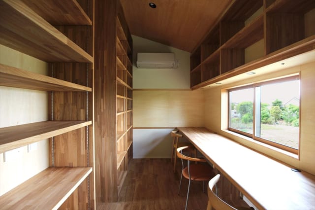 2階　スタディールーム／子どもの学習机としても使えるよう、眺めのいい窓の下に木のテーブルを配置。壁には本をたっぷり収納できる本棚を設けたほか、部屋の奥には貼り紙ができる木の壁も用意した