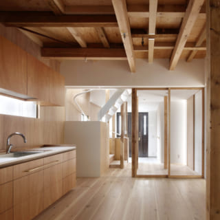 1階のキッチンのカウンターや棚は造作で作られたもの。素材はラワン材や杉など限定することで統一感を出した