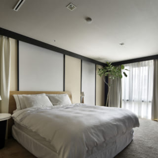 スクリーンや絨毯を敷くことで、どこかリゾート地を思わせる雰囲気のベッドルーム。枕元のランプなど、アジアンなリゾート気分を演出している