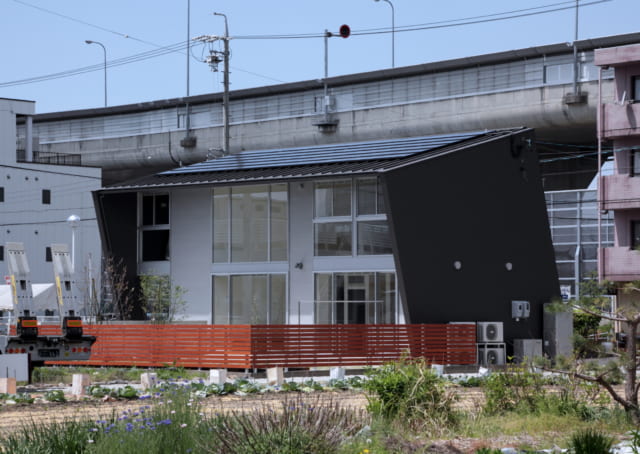 大屋根は南に14度傾き、太陽光パネルが設置されている。屋根が庇となり、横壁も張り出すことで西日もカットしている