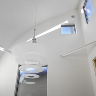 上から入る光が1階まで反射して届くように湾曲してつくられた天井。デザイン的にも空間に変化を与えている