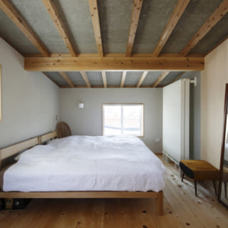 2階の主寝室。天井は低いところで1800㎜に抑えられ、屋根裏部屋のような雰囲気に。落ち着いてゆっくりと休める空間となっている