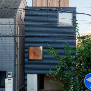 道路から見る外観／外壁は波板のガルバリウム鋼板を横張りにした。道路からの外観はすっきりと洗練されている。上部に覗く屋上の囲いの木製壁が帽子のよう