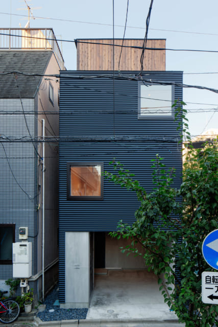 道路から見る外観／外壁は波板のガルバリウム鋼板を横張りにした。道路からの外観はすっきりと洗練されている。上部に覗く屋上の囲いの木製壁が帽子のよう