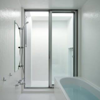 バスルームはサーファーには嬉しい、玄関を通らず直接入れる構造。窓ごしの中庭が露天風呂感を演出