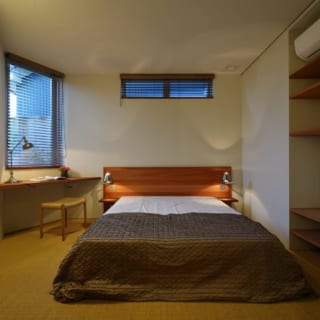 寝室。床はサイザル麻のカーペット。作り付けの棚の裏がウォークインクローゼットになっている