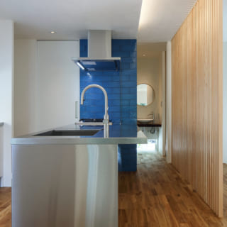 オールステンレスのスタイリッシュなキッチン。壁の一部に用いられたコバルトブルーのタイルが高級感を演出