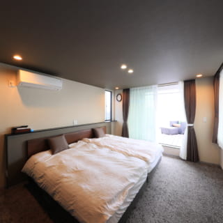 シックで洗練された3階の主寝室は、ホテルの客室のよう。写真奥の窓からルーフテラスに出ることができる