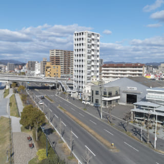 写真右手前、海沿いにあるカフェは街並みに馴染みつつも存在感を放つ。角地にあり道路と2面で接しているため、あえてどこからでも敷地に入れるような雰囲気をつくった。海側の植栽は店内から外を眺める人だけでなく、道行く人の目も楽しませている