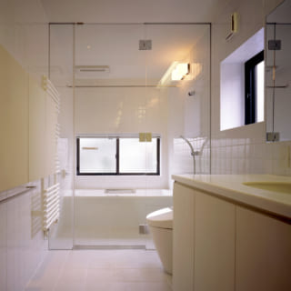 バスルーム、洗面、トイレはガラスで仕切られた一体型。バータイプのタオル乾燥機もホテルを思わせる