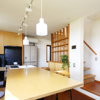 コンパクトで使いやすいキッチンと、シンクと一体となったテーブルが特徴。白い壁は、卵の殻を利用した素材で吸放湿抜群