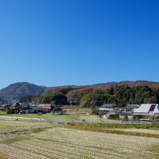 岡山県の田園風景に佇むKさん邸。遠景からは、屋根に穴があいたような独特のフォルムが存在感を発揮