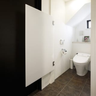 閉鎖空間が苦手という奥様に合わせたトイレの扉は、上下が開放された乳半アクリル製