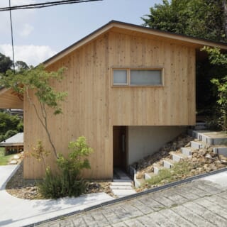 道路側から見たH邸の外観。土地を造成しない代わりに建物基礎を立ち上げ、建物自体で北側の土砂を受けられるよう工夫された