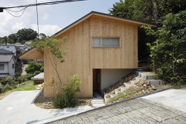 道路側から見たH邸の外観。土地を造成しない代わりに建物基礎を立ち上げ、建物自体で北側の土砂を受けられるよう工夫された