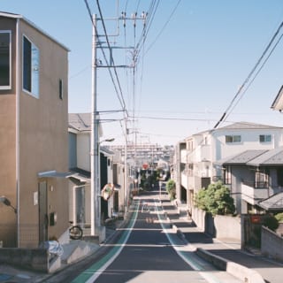 外観。写真左のブラウンの外壁の住宅がhouseA。ならだかに傾斜した住宅街の一角に立つ