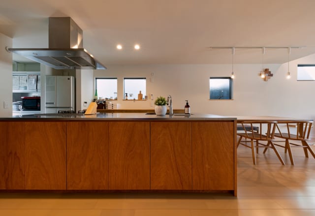 キッチンはオーダーメイドのアイランドキッチン。面材もリビング天井と素材を合わせ、ラワン材を採用することで、LDK空間全体でデザインに統一感をもたせている。すぐ横には、I様の要望でもあるパントリー収納も設置