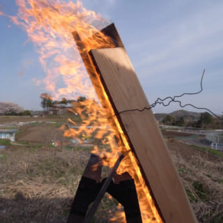 杉を焼く風景。杉を三角形に組み固定して、下から火をつける