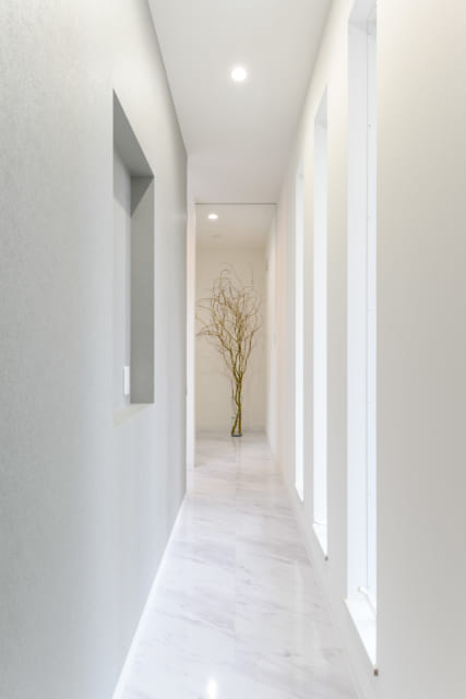 玄関からリビングに続く廊下も、ホテルの廊下の雰囲気を重視した。優しいグレーの壁面が場の印象を和らげる