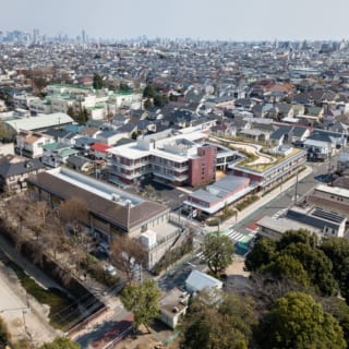 上空からの眺め。写真中央、広々とした屋上庭園のあるレンガ色の建物が『リバービレッジ杉並』。写真右手前の緑が妙正寺公園。左手前が妙正寺川。周辺は、緑に包まれた低層の住宅地