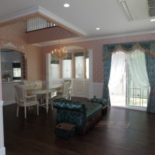 淡いピンクの壁紙に彩られたK邸のリビングには、海外製の家具やインテリアが並ぶ