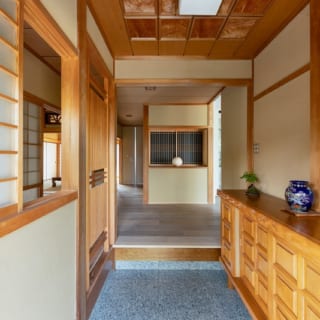 和テイストの玄関正面の飾り棚は元のものを生かしつつ、棚の背面は障子をはがして桟だけ残したモダンなデザインに変更