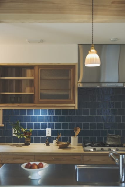 キッチンの壁タイルはFさまご夫妻が好きなブルー。磁器のランプシェードは益子の作家・伊藤叔潔さんの作品