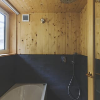 レインシャワー付きの浴室。木材は水に強く香りも爽やかな高野槙。床は炭化コルク、バスタブは鋳物ホーロー