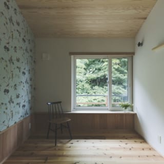 2階の洋室。木々を描いたウィリアム・モリスの壁紙が、窓越しの緑と自然素材の内装によく馴染む