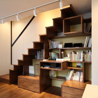 デットスペースになりがちな階段下を、本棚として活用することで、蔵書をインテリアに。本棚の高さと階段の寸法を緻密に計算し合わせたのだとか