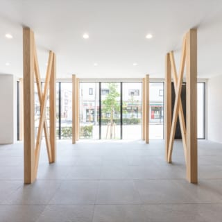 1階。通りからよく見えるスペースの床は高級感のあるタイル張り。柱や筋交いは、元の家の構造で使われていたものをメンテナンスして表に出した。木の質感や表情が、白を基調にしたシンプルモダンな空間のアクセントになっている