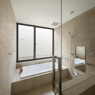 2階浴室。南の道路側に位置するが、壁で囲ったバスコートで視線をカット。朝や昼間は陽光の中で入浴できる