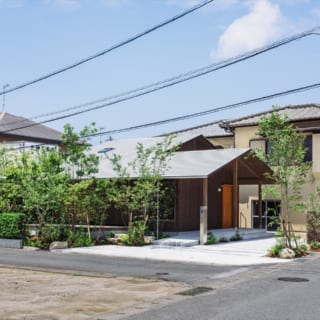 南東から見た外観。浦志の家が立つのは往来が多い東の道路（写真右）と南の生活道路（写真左手前）に面した南東角地。以前はご実家の別棟があった場所だ。長く低い軒が道路側をゆったり覆い、ずっと前からここに立っていたかのような控えめな印象となっている