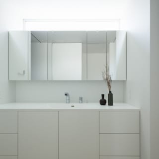 洗面台とミラーキャビネットは江ケ崎さんの設計。5人の家族が効率よく洗面を使える収納力に優れたデザイン