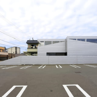 外観。異形窓は山の稜線をイメージしており、谷から光が入ってくることで視線をコントロールしている。塀は外壁と同じガルバリウム鋼板で仕上げている