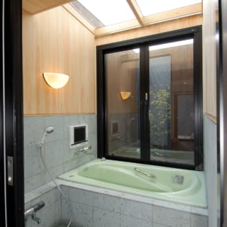 天井をガラス張りにした、明るい1階の浴室。奥の扉を開放すれば露天風呂の気分を味わえる