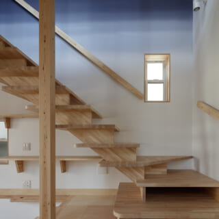 階段は、２階の生活が伺えないようあえて回り込むように設置。幅広のスケルトン階段とすることで、ギャラリーのような「見せる階段」とした