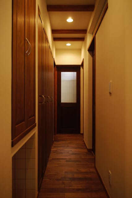 キッチン裏の廊下には、扉付きの大容量収納を備えた。一番手前の棚の下、タイル部分はワンちゃんのトイレ