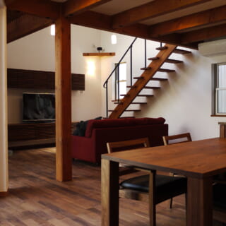 1階LDK。床は、ウォールナットを基調とする家具と素材を統一した。杉材や米松を用いた梁や柱の構造材もその色合いに合わせて着色し、全体的なバランスを考慮した。他にも壁と天井は全て漆喰で仕上げるなど、ほぼ全て自然素材が使用された贅沢な内部空間だ